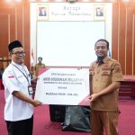 Gubernur SulSel, Andi Sudirman Sulaiman dan keluarga menyerahkan zakat yang diterima Ketua BAZNAS Sulsel, Muhammad Khidri Alwi di Baruga Karaeng Pattinggaloang, Selasa (11/4/2023).