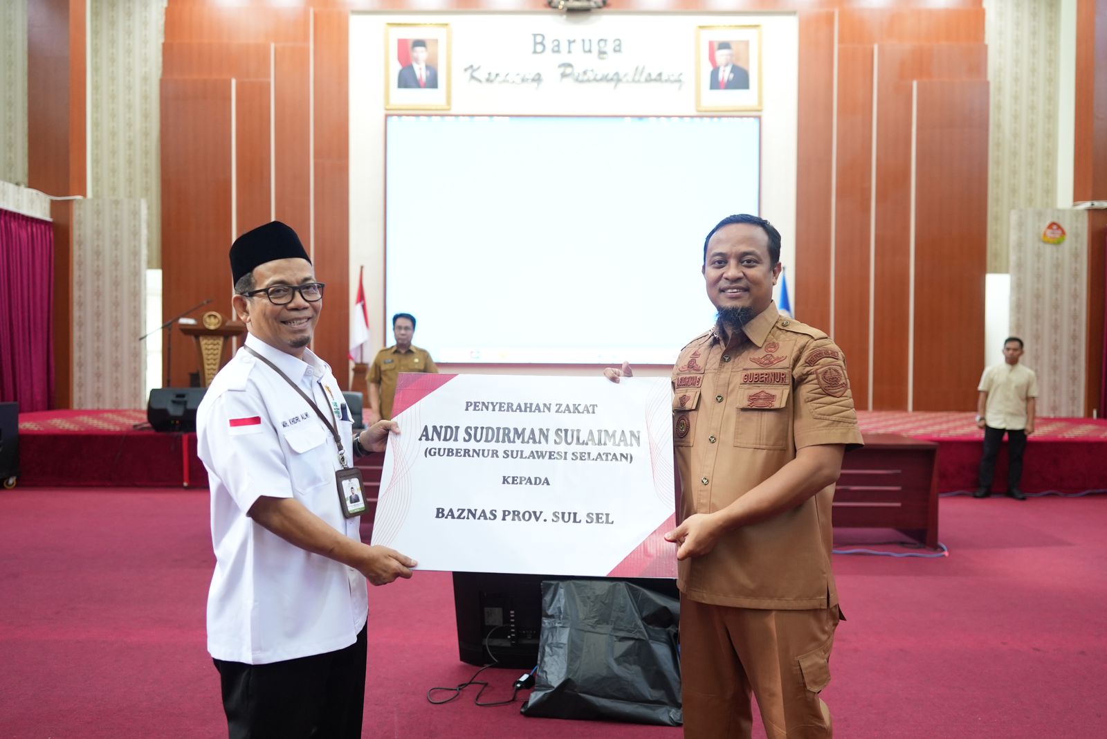 Gubernur SulSel, Andi Sudirman Sulaiman dan keluarga menyerahkan zakat yang diterima Ketua BAZNAS Sulsel, Muhammad Khidri Alwi di Baruga Karaeng Pattinggaloang, Selasa (11/4/2023).
